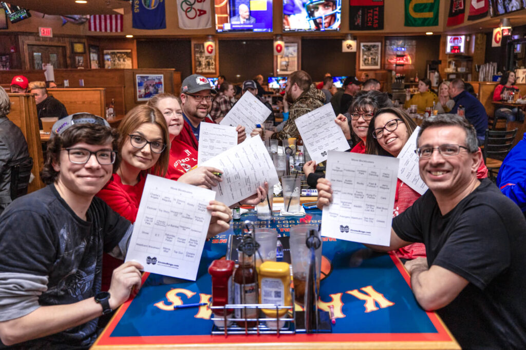 A group of people holding up papers at a table.