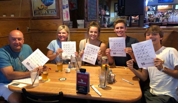 A group of people sitting at a table holding up signs.